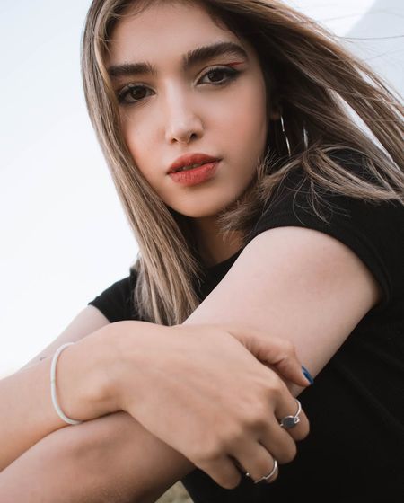 Woman in a serene yoga pose against a dark graphite background with frost-colored light.
